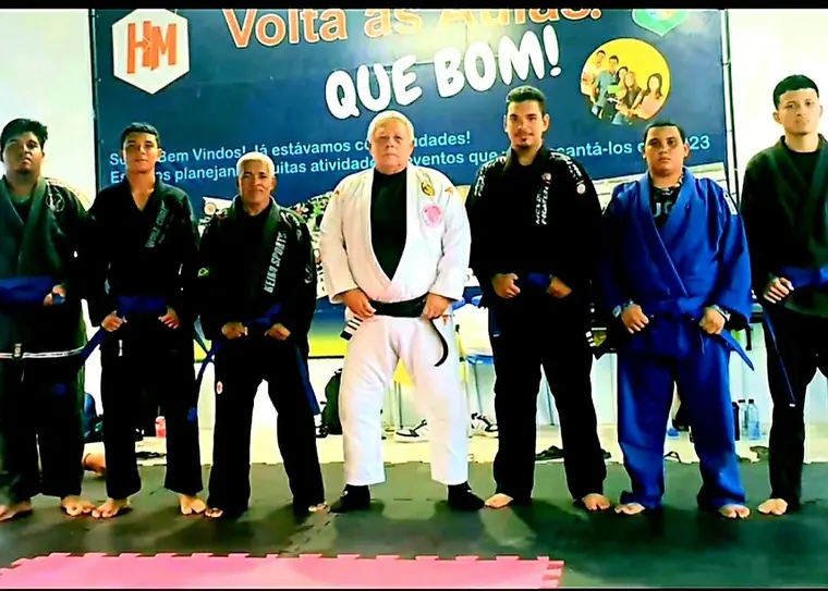 Alunos graduados do Impacto Dōjō alinhados no tatame com o Mestre Dunga
