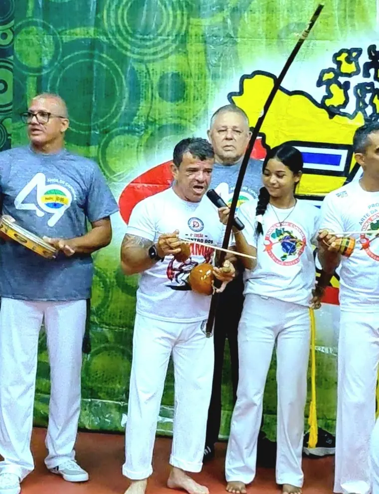 Capoeiristas segurando berimbaus