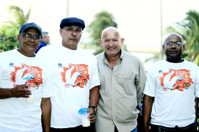 Mestres de capoeira reunidos na praia